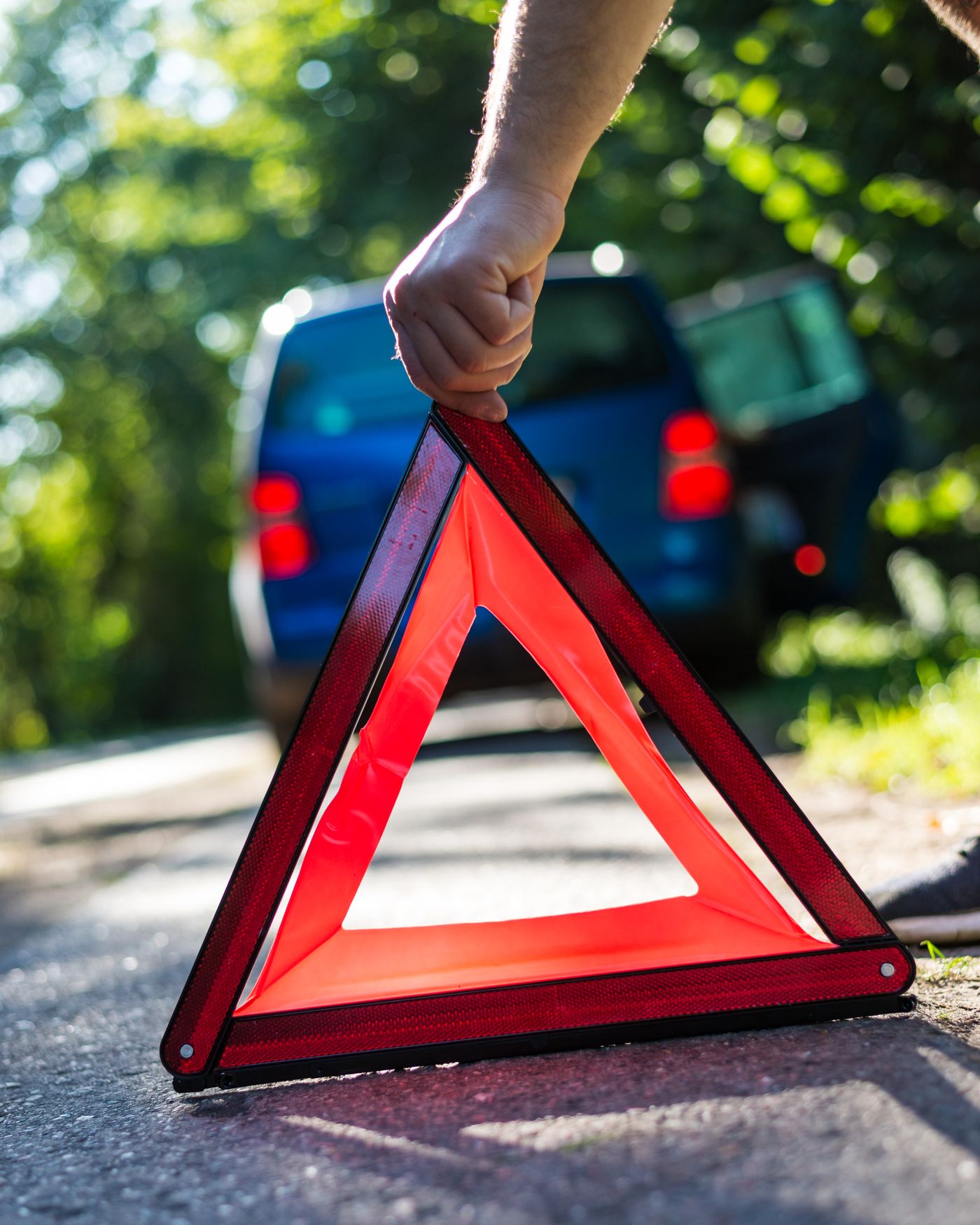Aufgestelltes Warndreieck hinter einem abgestellten Transporter